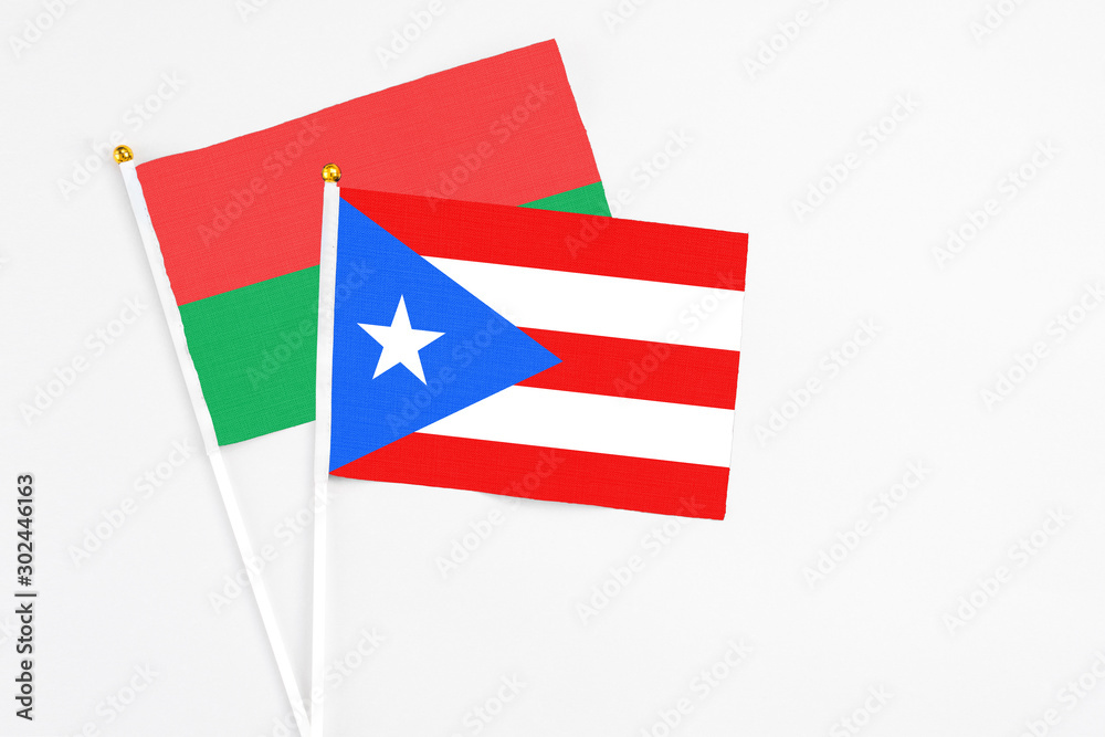 Puerto Rico and Burkina Faso stick flags on white background. High quality fabric, miniature national flag. Peaceful global concept.White floor for copy space.