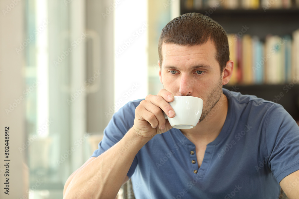 Distracted adult man drinking coffee in a bar or home Distracted adult man drinking coffee in a bar or home