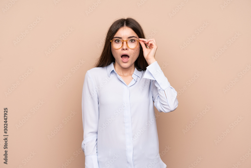 Young woman over isolated background with glasses and surprised