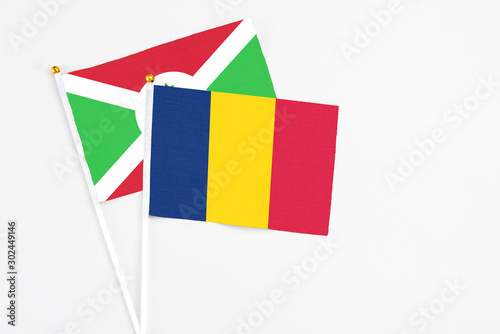 Chad and Burundi stick flags on white background. High quality fabric, miniature national flag. Peaceful global concept.White floor for copy space.
