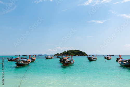 Koh Lipe, Andaman sea, Thailand. Beautiful Island of Koh Lipe, Long-tailed boat parking during Sunrise and Sunset by the beach. Beautiful white beach, blue sea with long tail boats in summer.