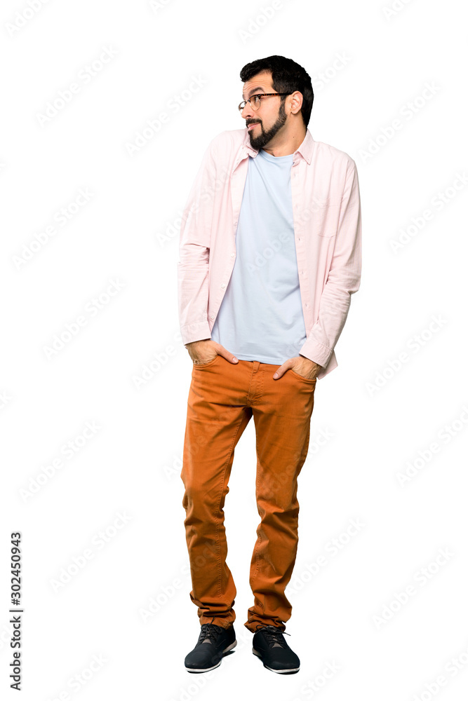 Full-length shot of Handsome man with beard making doubts gesture looking side over isolated white background Full-length shot of Handsome man with beard making doubts gesture looking side over isolated white background