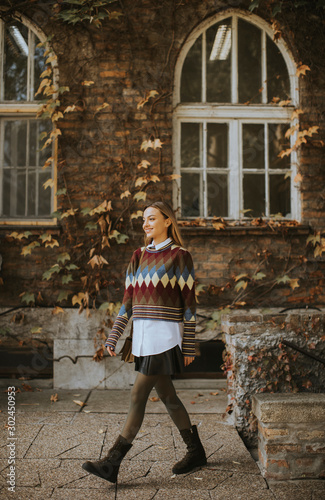 Pretty young woman walking in the autumn park