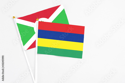 Mauritius and Burundi stick flags on white background. High quality fabric, miniature national flag. Peaceful global concept.White floor for copy space.