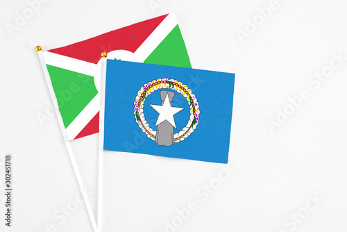 Northern Mariana Islands and Burundi stick flags on white background. High quality fabric, miniature national flag. Peaceful global concept.White floor for copy space.