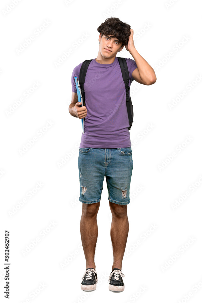 A full-length shot of a Young student man with an expression of frustration and not understanding over isolated white background A full-length shot of a Young student man with an expression of frustration and not understanding over isolated white background
