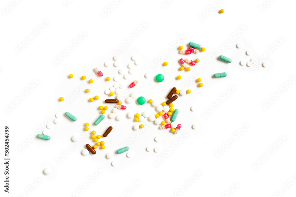 Many various pills, tablets and capsules on the white background