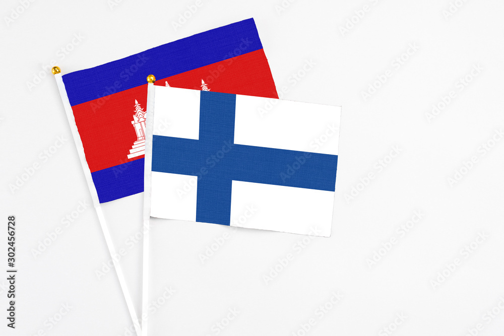 Finland and Cambodia stick flags on white background. High quality fabric, miniature national flag. Peaceful global concept.White floor for copy space.