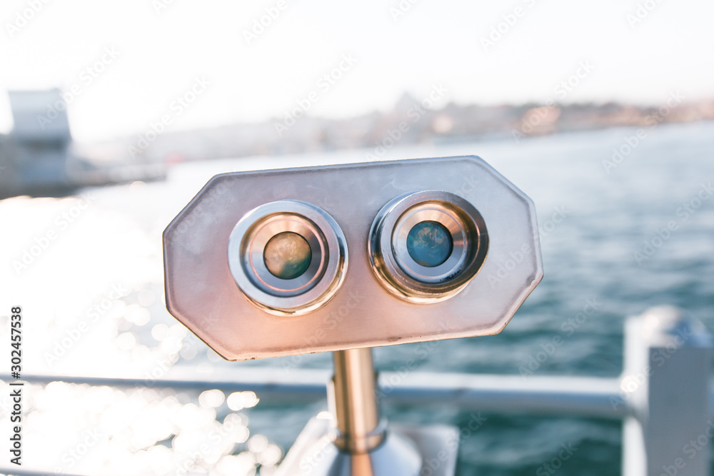 Coin Operated Binocular viewer next to the waterside promenade in Istanbul, Turkey looking out to Bosphorus Strait and city. Focus on binoculars.