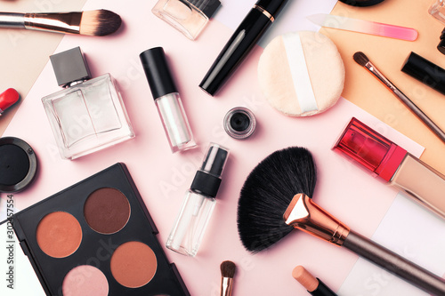 Makeup products and cosmetics on multi color background, flat lay. Fashion and beauty blogging concept. Top view