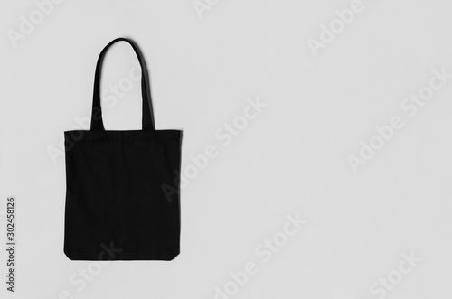 Black tote bag mockup on a grey background with copyspace.