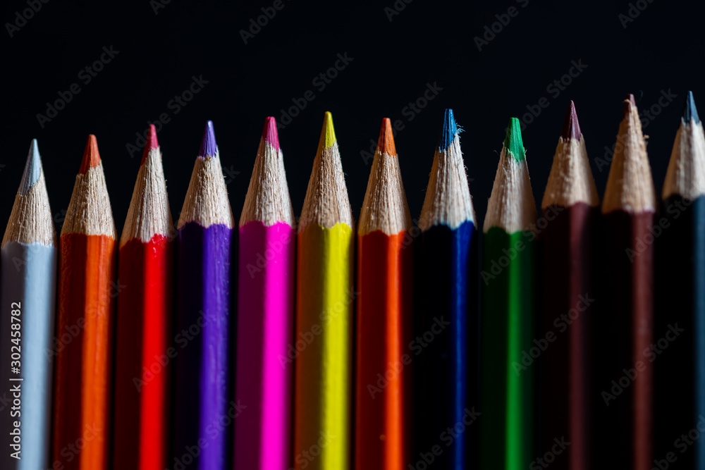 Coloured pencils isolated on black background close up. Vintage look Macro photography. Pencils Wallpaper. Bundle of rainbow colored pencils with selected focus on tips. Multicolored rainbow pencils. Coloured pencils isolated on black background close up. Vintage look Macro photography. Pencils Wallpaper. Bundle of rainbow colored pencils with selected focus on tips. Multicolored rainbow pencils.