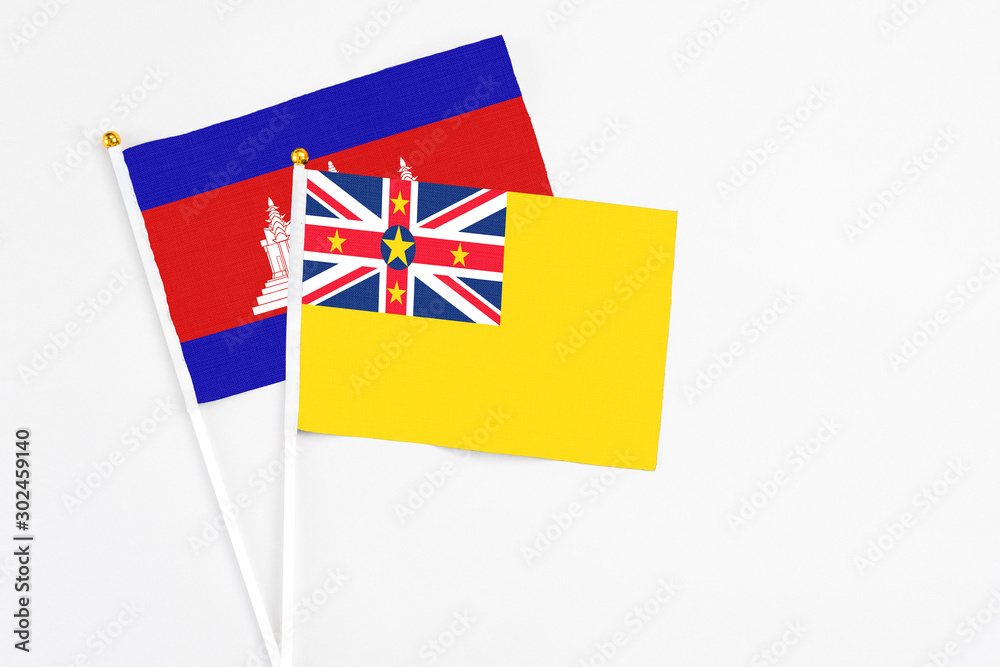 Niue and Cambodia stick flags on white background. High quality fabric, miniature national flag. Peaceful global concept.White floor for copy space. Niue and Cambodia stick flags on white background. High quality fabric, miniature national flag. Peaceful global concept.White floor for copy space.