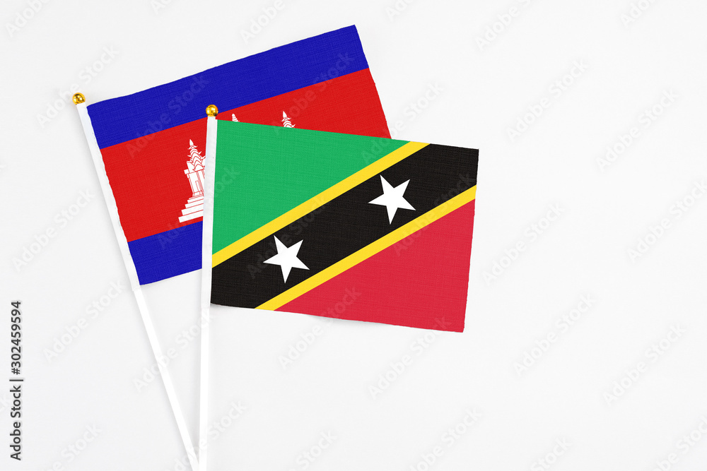 Saint Kitts And Nevis and Cambodia stick flags on white background. High quality fabric, miniature national flag. Peaceful global concept.White floor for copy space. Saint Kitts And Nevis and Cambodia stick flags on white background. High quality fabric, miniature national flag. Peaceful global concept.White floor for copy space.