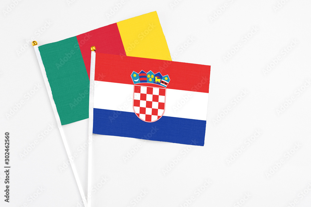Naklejka premium Croatia and Cameroon stick flags on white background. High quality fabric, miniature national flag. Peaceful global concept.White floor for copy space.