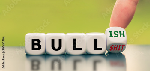 Obraz na plátně Hand turns a dice and changes the expression bull shit to bullish