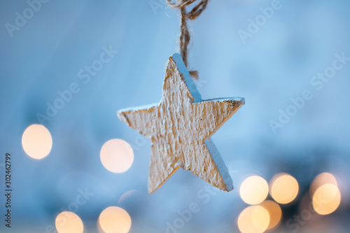 Weißer Holzstern mit Lichtern im Hintergrund - Weihnachtszeit photo