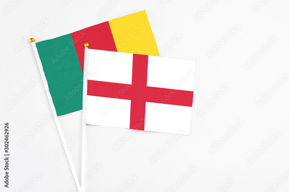 England and Cameroon stick flags on white background. High quality fabric, miniature national flag. Peaceful global concept.White floor for copy space.