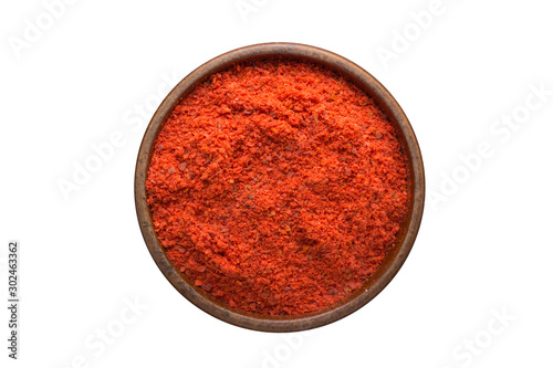 Fototapeta Naklejka Na Ścianę i Meble -  Adjika powder spice in wooden bowl, isolated on white background. Seasoning top view