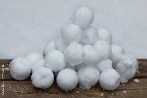A slide of stuck snowballs on a wooden bench in the yard.