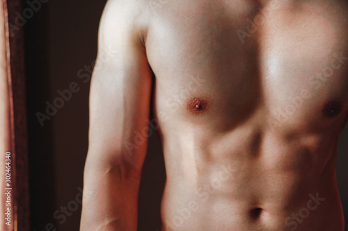 Strong Athletic Asian Man showing muscular body and sixpack abs in close-up shot.