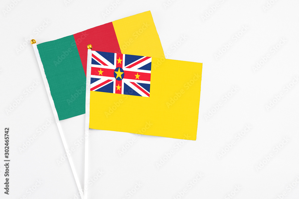 Niue and Cameroon stick flags on white background. High quality fabric, miniature national flag. Peaceful global concept.White floor for copy space. Niue and Cameroon stick flags on white background. High quality fabric, miniature national flag. Peaceful global concept.White floor for copy space.
