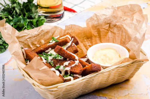 Beer snack fried croutons with cheese sauce in the basket. Rye bread croutons with garlic, oil and salt.