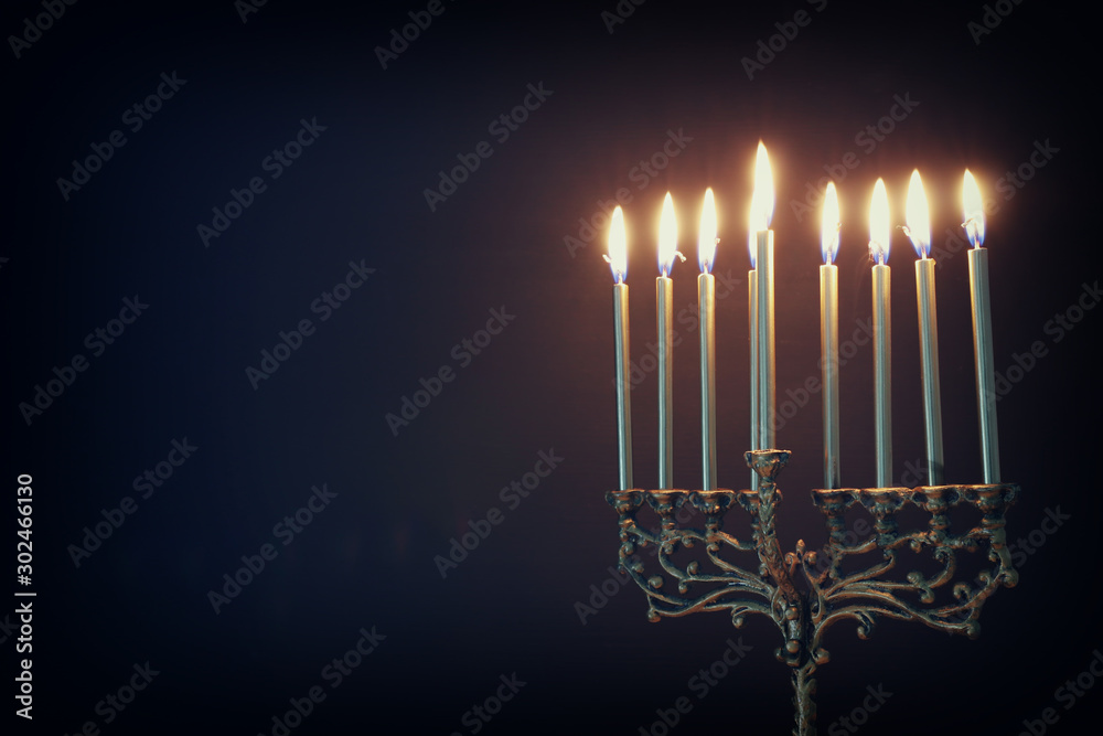 Fototapeta premium Religion image of jewish holiday Hanukkah background with menorah (traditional candelabra) and candles
