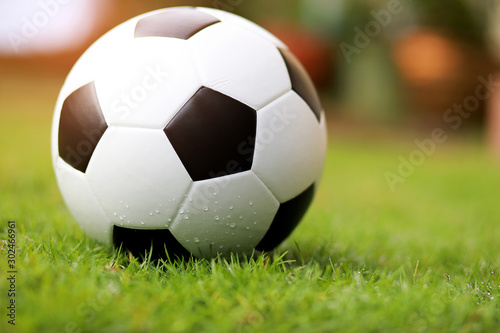 Close up soccer ball or football on green grass with sunrise background. Sport concept.