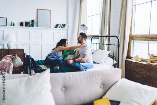 Woman going to hug boyfriend on bed