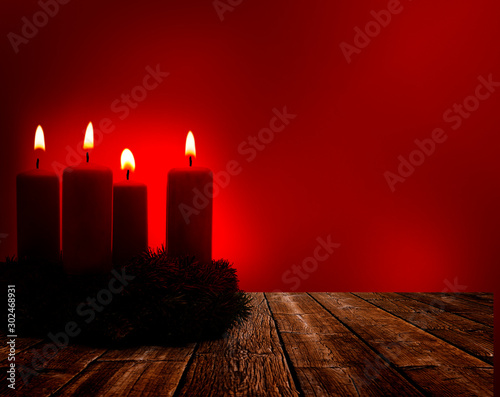 Vier brennende Weihnachtskerzen auf einem Adventskranz