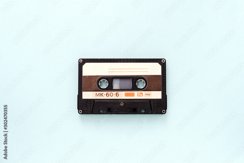 Audio tape cassette on a light blue background close-up. Top view Audio tape cassette on a light blue background close-up. Top view