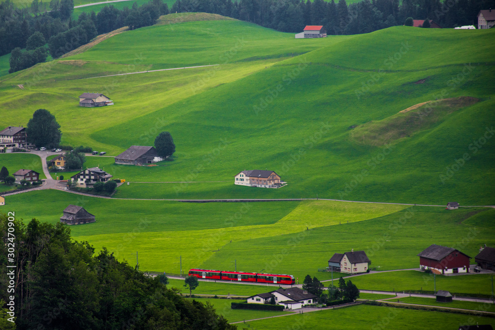 Valley, mountain and train in Switzerland, green background