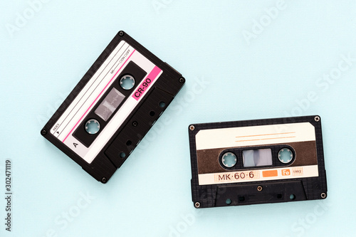 Two vintage audio tapes on a light blue background close-up. Top view