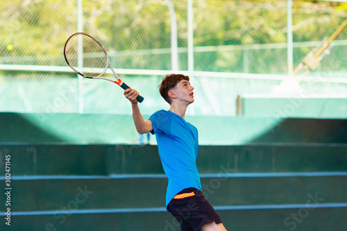 Young man playing tennis on open court © famveldman
