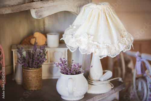 Still life in the style of provence. White lampshade dry lavender flowers stand on a table