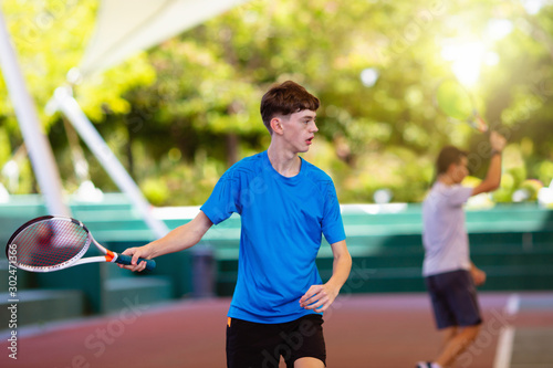 Young man playing tennis on open court