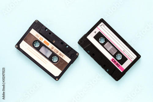 Two vintage audio tapes on a light blue background close-up. Top view