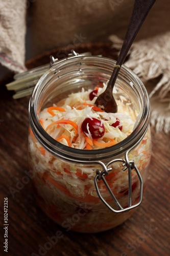 Homemade Traditional sauerkraut with carrots and cranberries in a glass jar