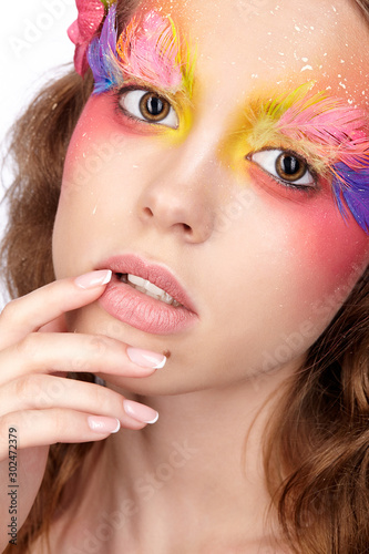 Female with hand near face and fashion feather eyelashes make-up