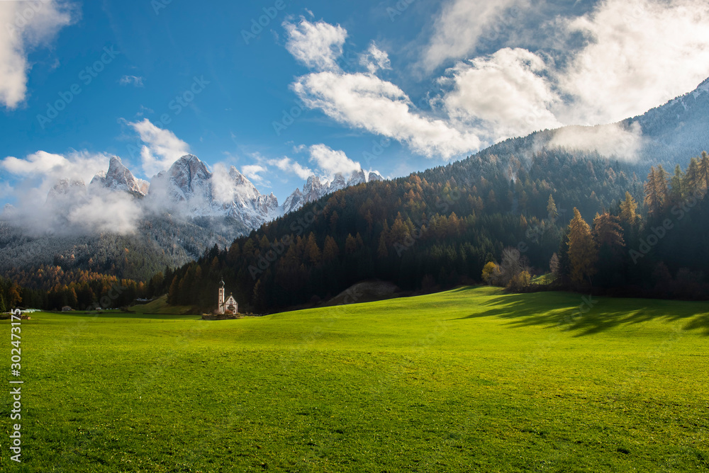 Beautiful landscape with Italian Alps  and colorful foreground with Church of Saint John locatade in Ranui, Italy.