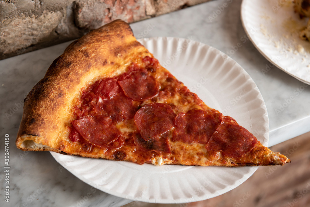 Slice of pepperoni pizza on a paper plate Slice of pepperoni pizza on a paper plate