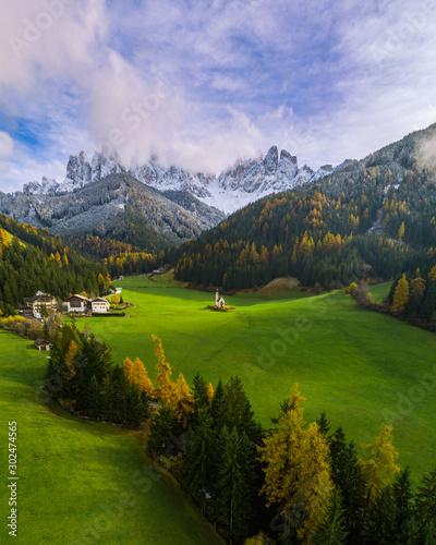 Beautiful landscape with Italian Alps and colorful foreground with Church of Saint John locatade in Ranui, Italy / Aerial view