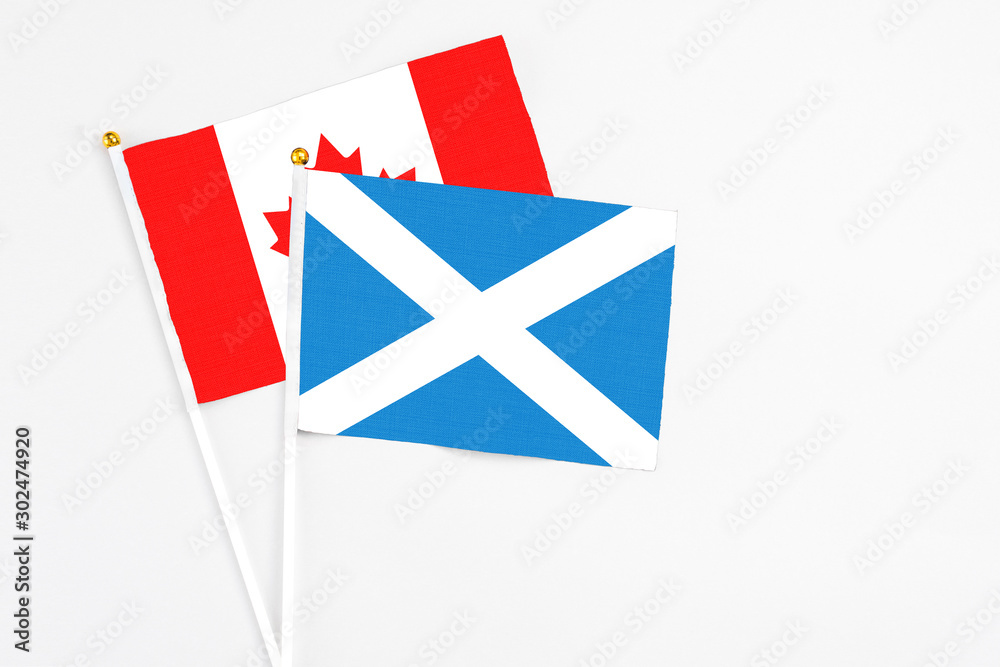 Scotland and Canada stick flags on white background. High quality fabric, miniature national flag. Peaceful global concept.White floor for copy space.