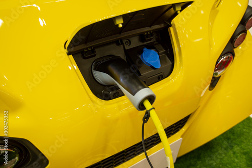 Yellow electric car at charging in station