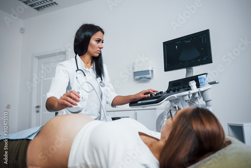 Female doctor does ultrasound for a pregnant woman in the hospital