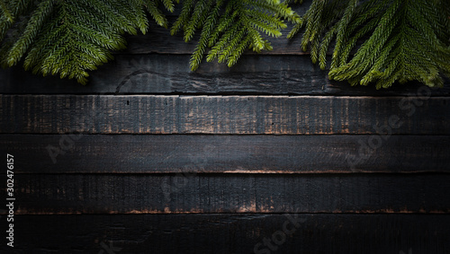 Christmas tree branches on dark wooden background  with copy space. Flat lay
