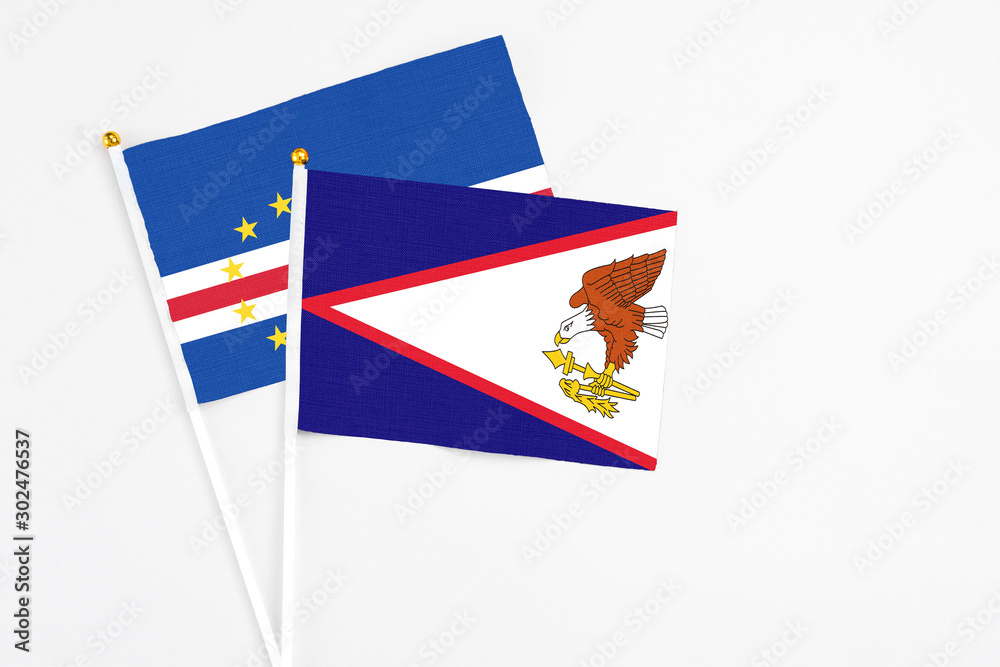American Samoa and Cape Verde stick flags on white background. High quality fabric, miniature national flag. Peaceful global concept.White floor for copy space. American Samoa and Cape Verde stick flags on white background. High quality fabric, miniature national flag. Peaceful global concept.White floor for copy space.