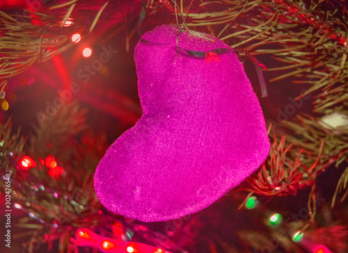 Christmas background pink heart on the background of fir tree branches with red lighting, futuristic neon festive background photo