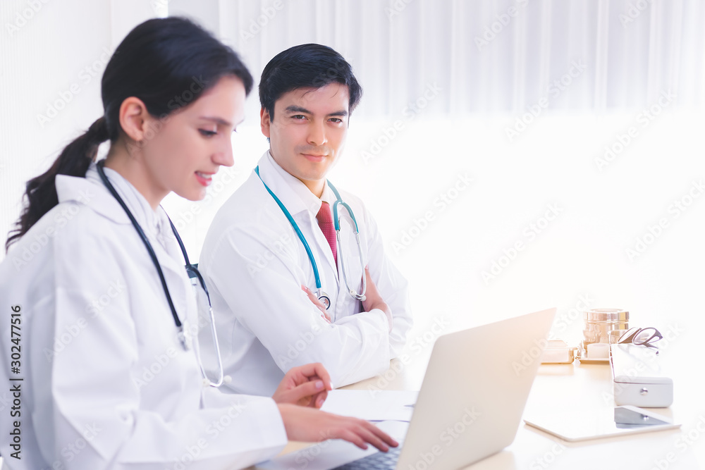 Smart doctor look confident, determined. Teacher look at camera and teaching young intern or medical student in hospital office at hospital or university. Professional doctor is specialist doctor. Smart doctor look confident, determined. Teacher look at camera and teaching young intern or medical student in hospital office at hospital or university. Professional doctor is specialist doctor.